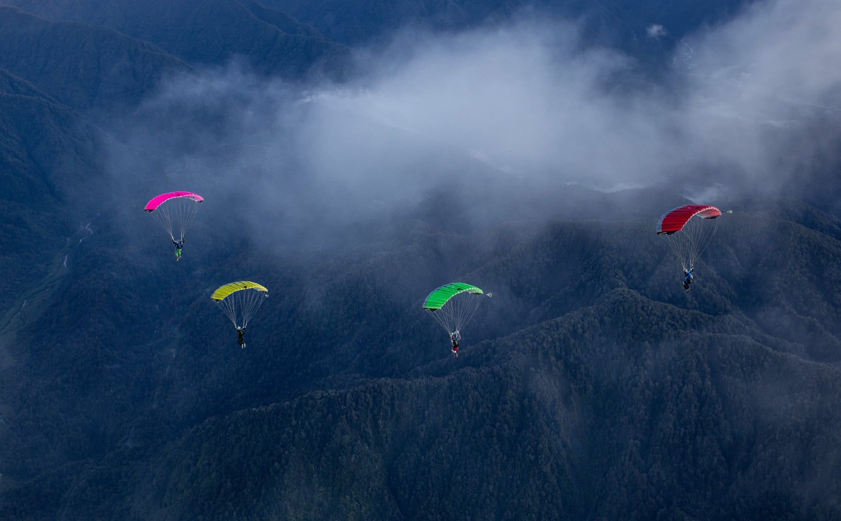 crossfire-3-gallery-images-canopies-flying-over-mountains-and-forest-pink-yellow-green-red